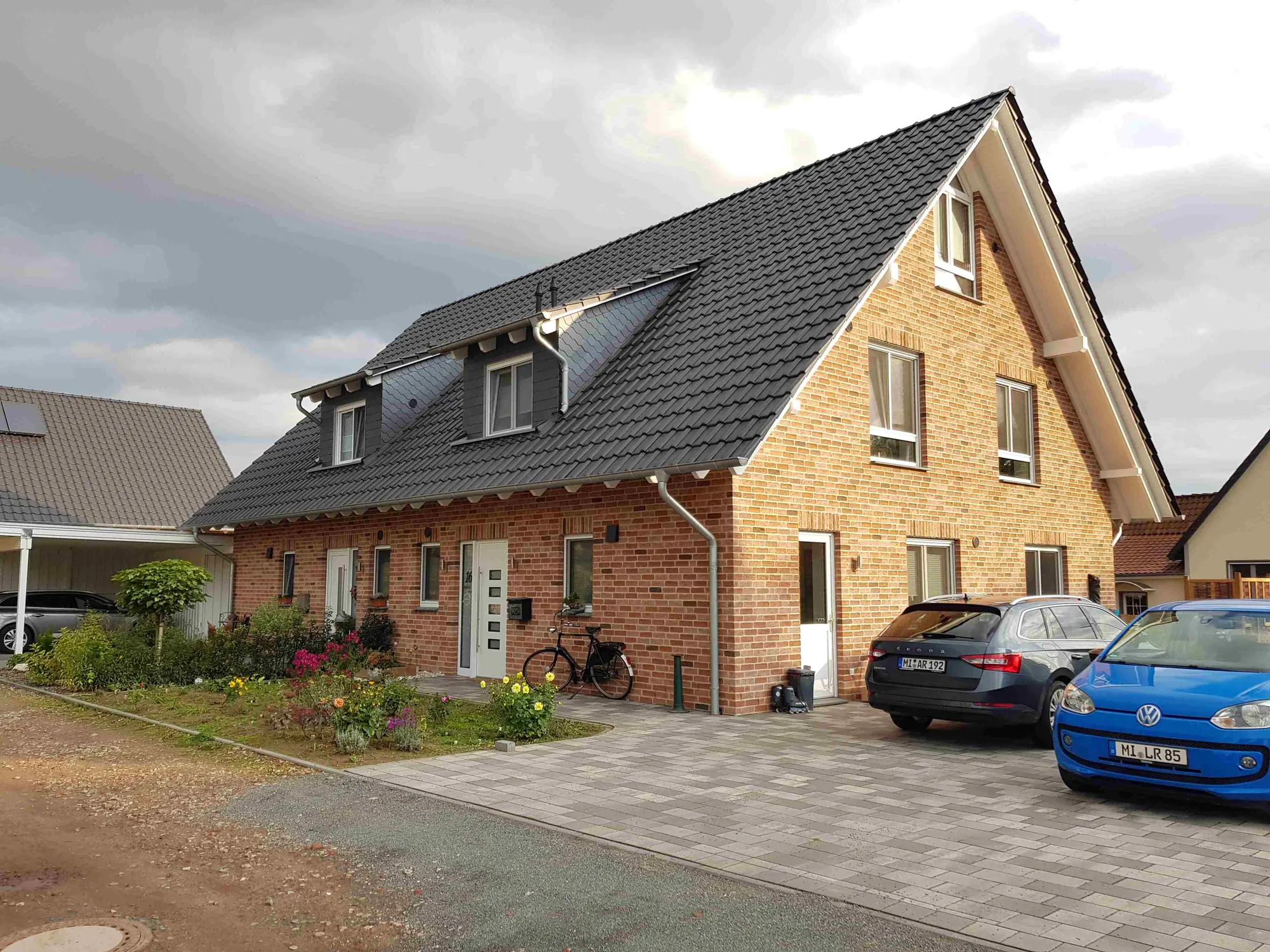 Neu gebautes Doppelhaus mit Klinkerfassade und Pflasterauffahrt