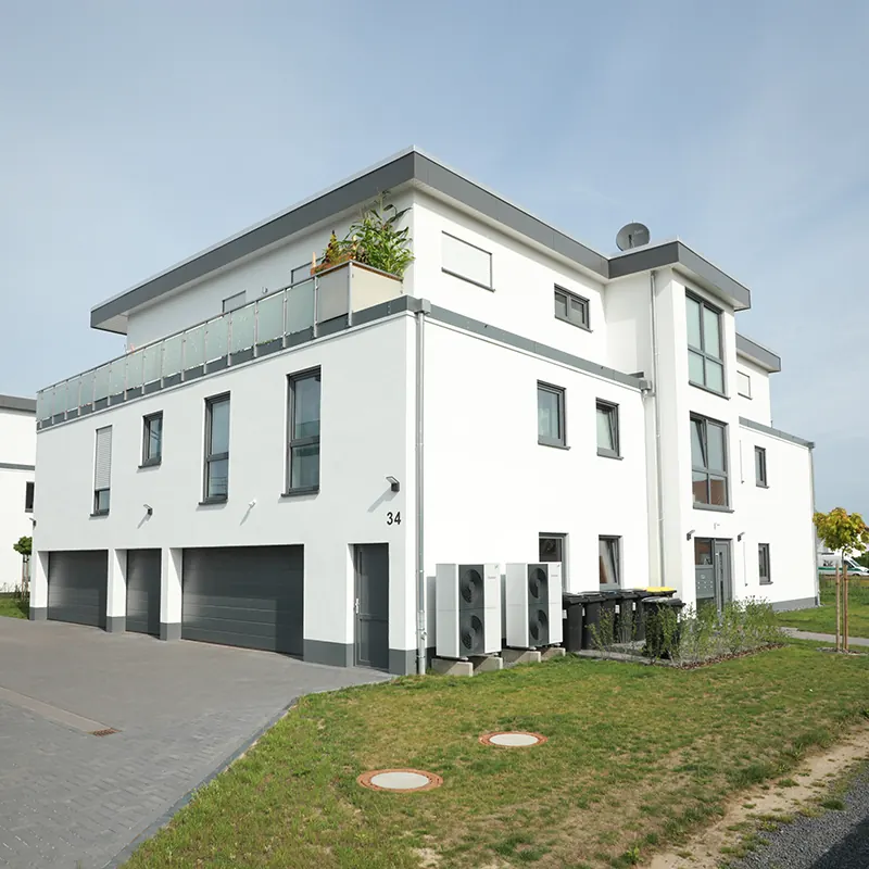Weißes Mehrfamilienhaus mit Staffelgeschoss